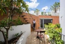 Nowoczesny taras na dachu z zielonym ogrodem i meblami, idealne miejsce do relaksu i spotkań, otoczone drzewami i roślinami, w centrum miasta w Polsce.